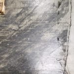 Close-up of neglected densified concrete floor with embedded dirt, scuffs, and surface contamination before treatment with CreteClean Plus concrete floor cleaner