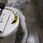 Auto scrubber applying CreteClean Plus concrete floor cleaner, lifting and suspending soil from a polished concrete warehouse floor