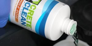 CreteClean Plus concrete floor cleaner single dose bottle being poured
